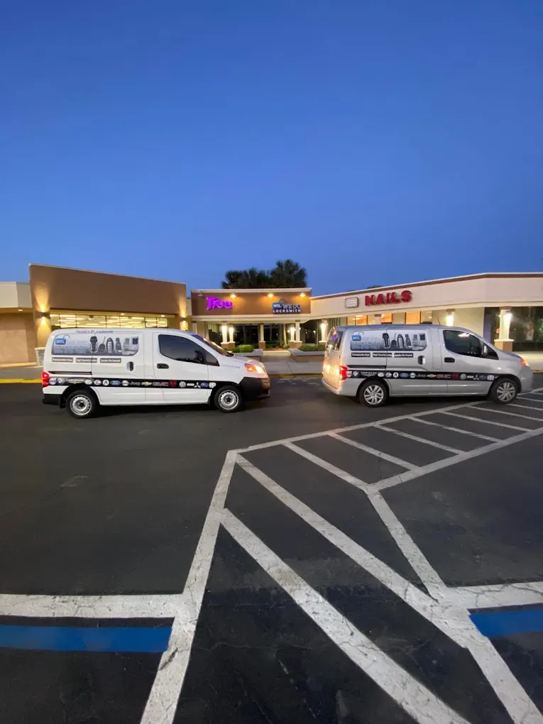 Two WDJ Locksmith vans parked in a shopping plaza at dusk